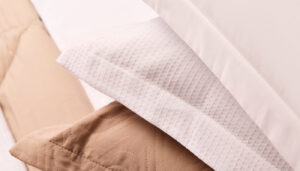 Fronhas profissionais brancas e beges que otimizam tempo e custo na lavanderia hoteleira