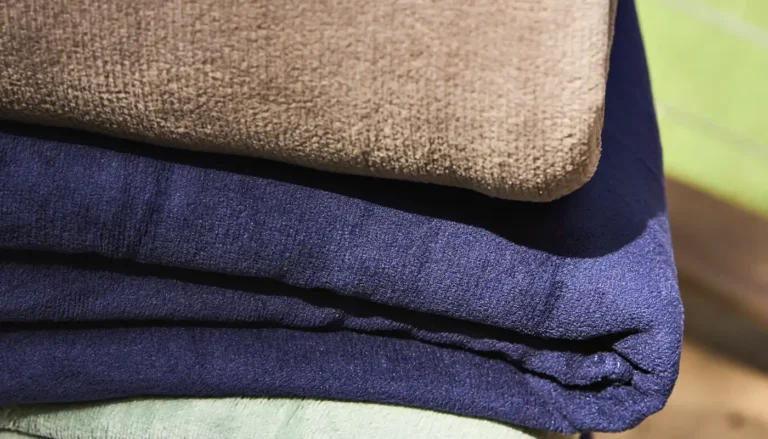 Cobertores de microfibra dobrados em hotel destacando conforto e praticidade na hotelaria