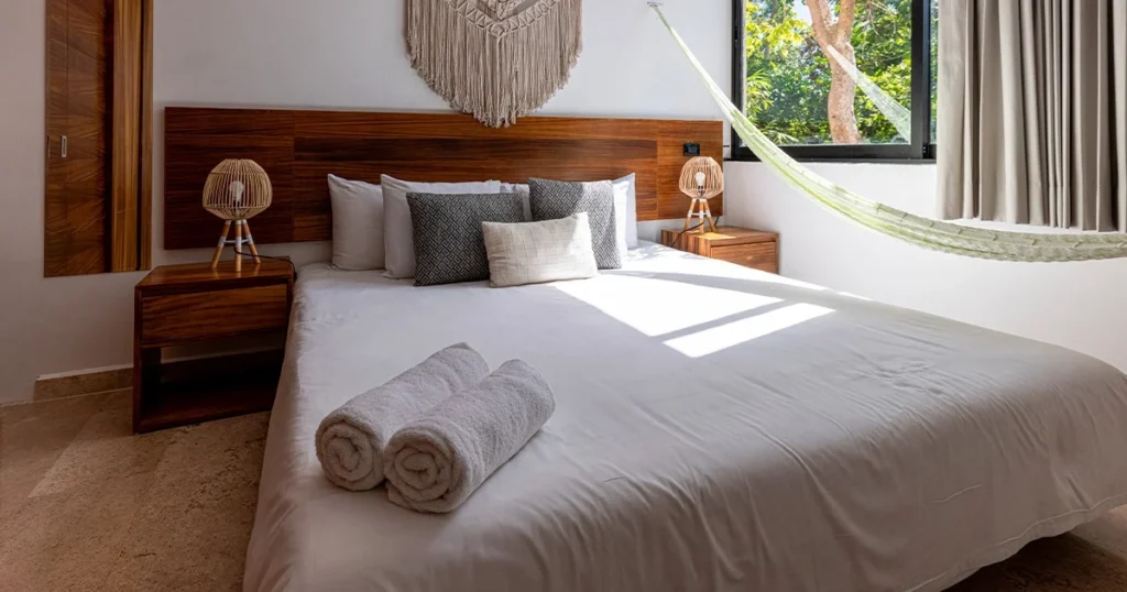 Quarto de hospedagem com cama arrumada e toalhas brancas para hotelaria