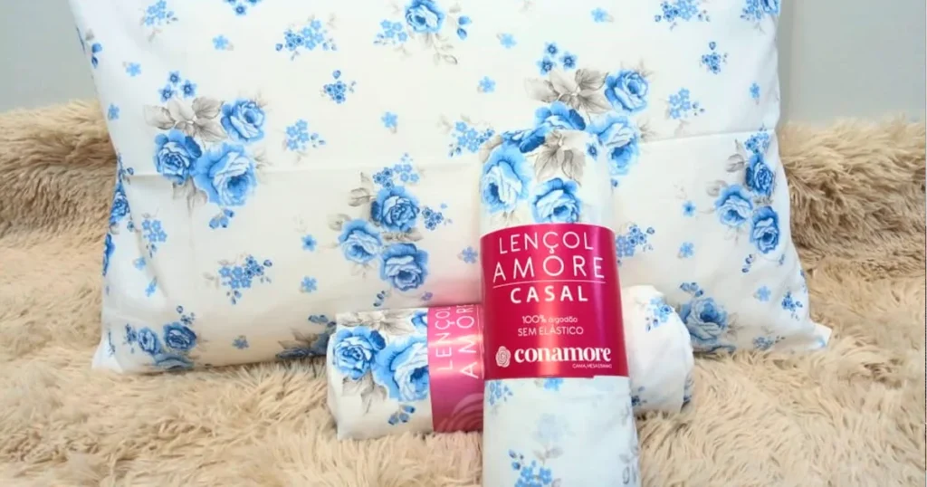 Jogo de lençol floral Conamore com estampa azul sobre cama felpuda