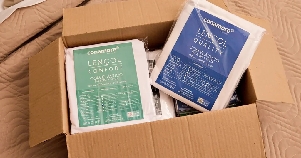 Caixa com lençóis para hotelaria da Conamore prontos para envio e distribuição
