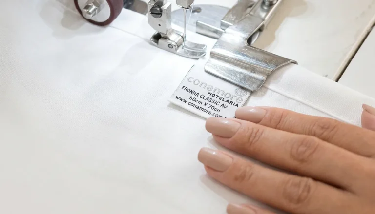 Colaboradora da Conamore realizando controle de qualidade em enxoval profissional para hotelaria e hospitalidade